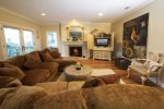 This comfortable living room includes a flat screen TV, DVD player, and a gas fireplace